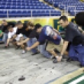 Eric Halvorson, right, technical manager for the Fargodome, leads the conversion crew in rolling out the turf for the endzone area of the field. The endzone turf is then zipped to the main turf to complete the football field. Carrie Snyder / The Forum